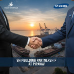 Two business professionals shaking hands with a shipyard and ships at sunset in the background, symbolizing a partnership.