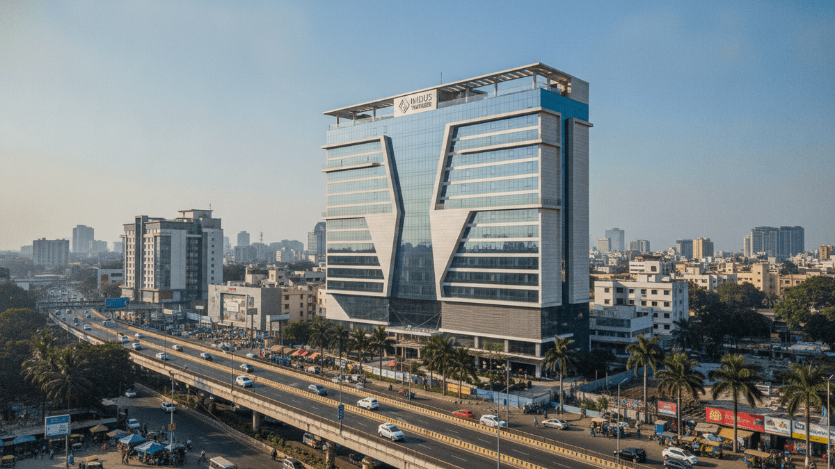 Wide shot of a modern hotel in an Indian city, with a busy street and city skyline in the background under daylight.