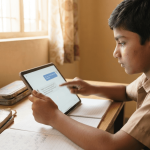 A 10-year-old Indian child touches a tablet screen displaying a generic AI tutor app, sitting at a wooden desk in a sunlit home.